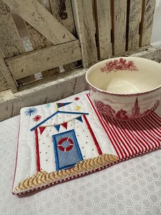 a bowl sitting on top of a red and white place mat next to a cup