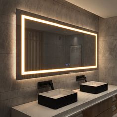 a bathroom with two sinks and a large lighted mirror above the sink area in front of it