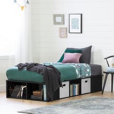 a bedroom with a bed, chair and bookcases on the floor in front of a window