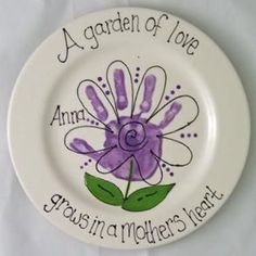 a white plate with a purple flower on it that says, a garden of love grows in a mother's heart