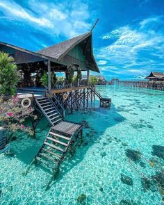 the water is crystal blue and clear with steps leading up to an overwater restaurant