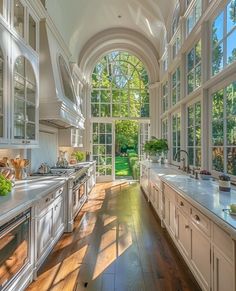 a large kitchen with lots of windows and white cabinets on both sides of the room