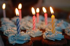 cupcakes with blue frosting and lit candles