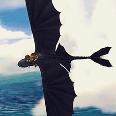 a black dragon flying over the ocean with clouds in the backgroung and two people on it