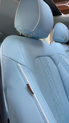 the interior of a car with light blue leather and white stitching on the seats