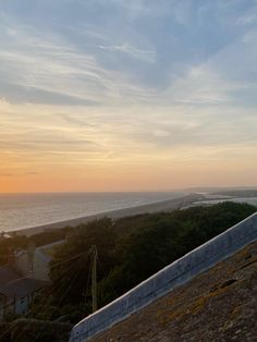 the sun is setting over the ocean and houses