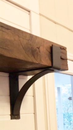 a close up of a wooden shelf with metal brackets