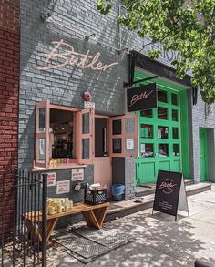 the outside of a restaurant with green doors