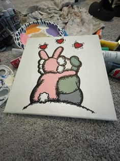 a drawing of a bunny hugging another bunny on the ground with other items around it