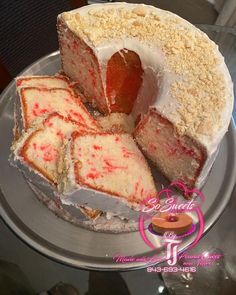 a cake with white frosting and red sprinkles sitting on a plate