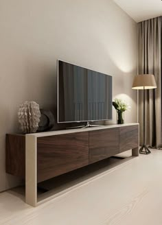 a large flat screen tv sitting on top of a wooden entertainment center in a living room