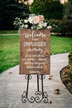 a wooden sign with flowers on it that says welcome to our unplugged ceremony