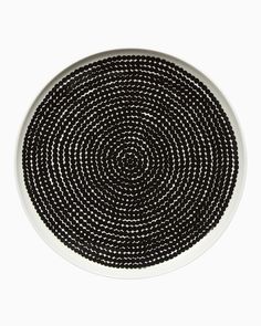 a black and white plate sitting on top of a white tablecloth covered in beads