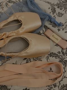 three pairs of ballet shoes on a bed