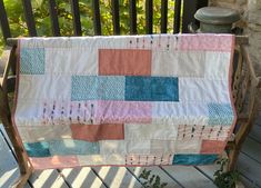 a patchwork quilt sitting on top of a wooden bench