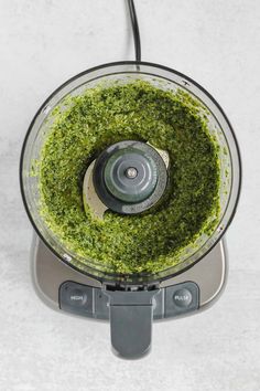 a food processor filled with green stuff on top of a white counter next to the words clean