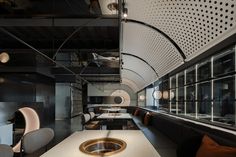 the interior of a modern restaurant with white counter tops and black walls, along with large windows