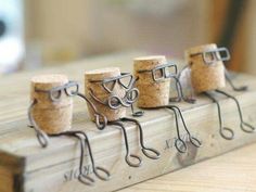 several corks are lined up on the edge of a window sill with eyeglasses attached to them