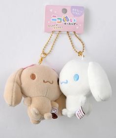 two small stuffed animals are attached to a key chain