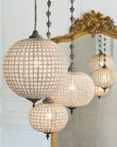 three lights hanging from a chandelier in front of a mirror