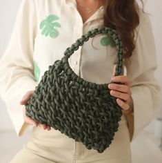 a woman holding a green purse in her hands