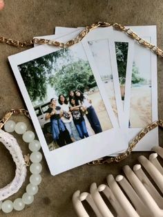 several polaroid photos are hanging on a chain next to a radiator and bracelet