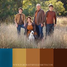 three people and a dog are posing for a photo in tall grass with trees behind them