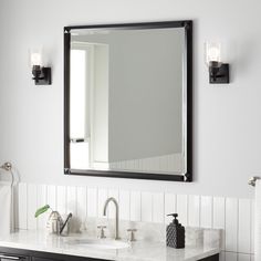 a bathroom with two sinks and a large mirror on the wall above it's counter