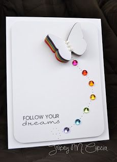 a white greeting card with a butterfly on the front and rainbow beads on the back