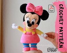 a crocheted minnie mouse doll is being held up