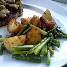 a white plate topped with potatoes and asparagus