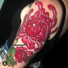 a woman's arm with red flowers and green leaves on the left side of her arm