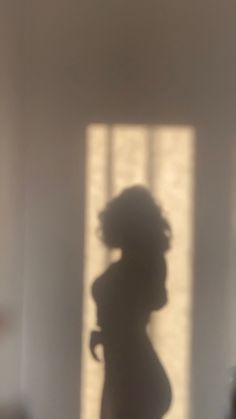 the shadow of a woman standing in front of a window