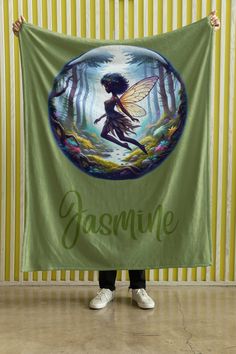 a woman holding up a green banner with a fairy on it that says, yasmine