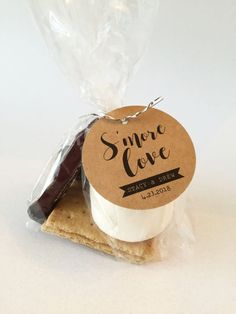 some crackers are wrapped in plastic and sitting on top of each other with a tag that says, s'more love