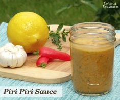 there is a jar of mustard next to some vegetables and a lemon on a cutting board