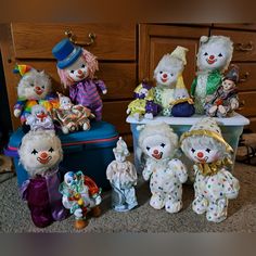 a group of stuffed animals sitting on top of a blue suitcase next to a dresser