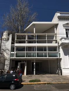 an apartment building with balconies and balconies on the second floor is white