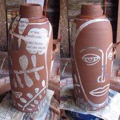 two clay vases with faces on them sitting next to each other