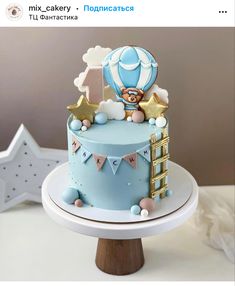 a blue and white cake with an air balloon on top