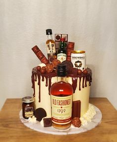 a cake that is sitting on top of a table with liquor bottles and candies