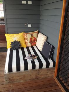 a black and white striped bench sitting on top of a wooden floor next to a wall