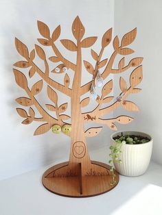 a wooden tree with birds on it next to a potted plant