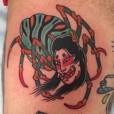 a woman with a spider tattoo on her leg