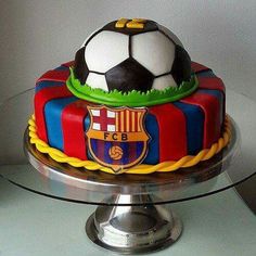 a cake with a soccer ball on top of it sitting on a glass platter