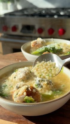 two bowls filled with soup on top of a wooden table