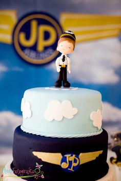 there is a cake that has a small figure on top of it, and an airplane in the background