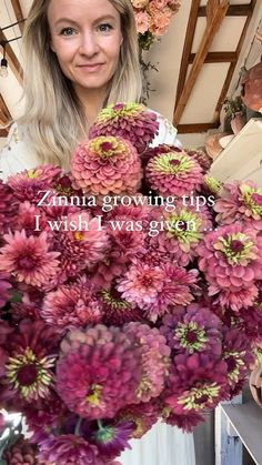 a woman holding a large bouquet of flowers with the words, zinna growing tips i wish i was given