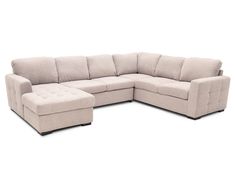 a large sectional couch sitting on top of a white floor next to a footstool