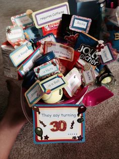 a basket filled with lots of different items on top of a carpeted floor next to a table